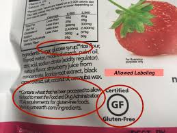A gluten-free label on a packaged food product beside a shopping basket